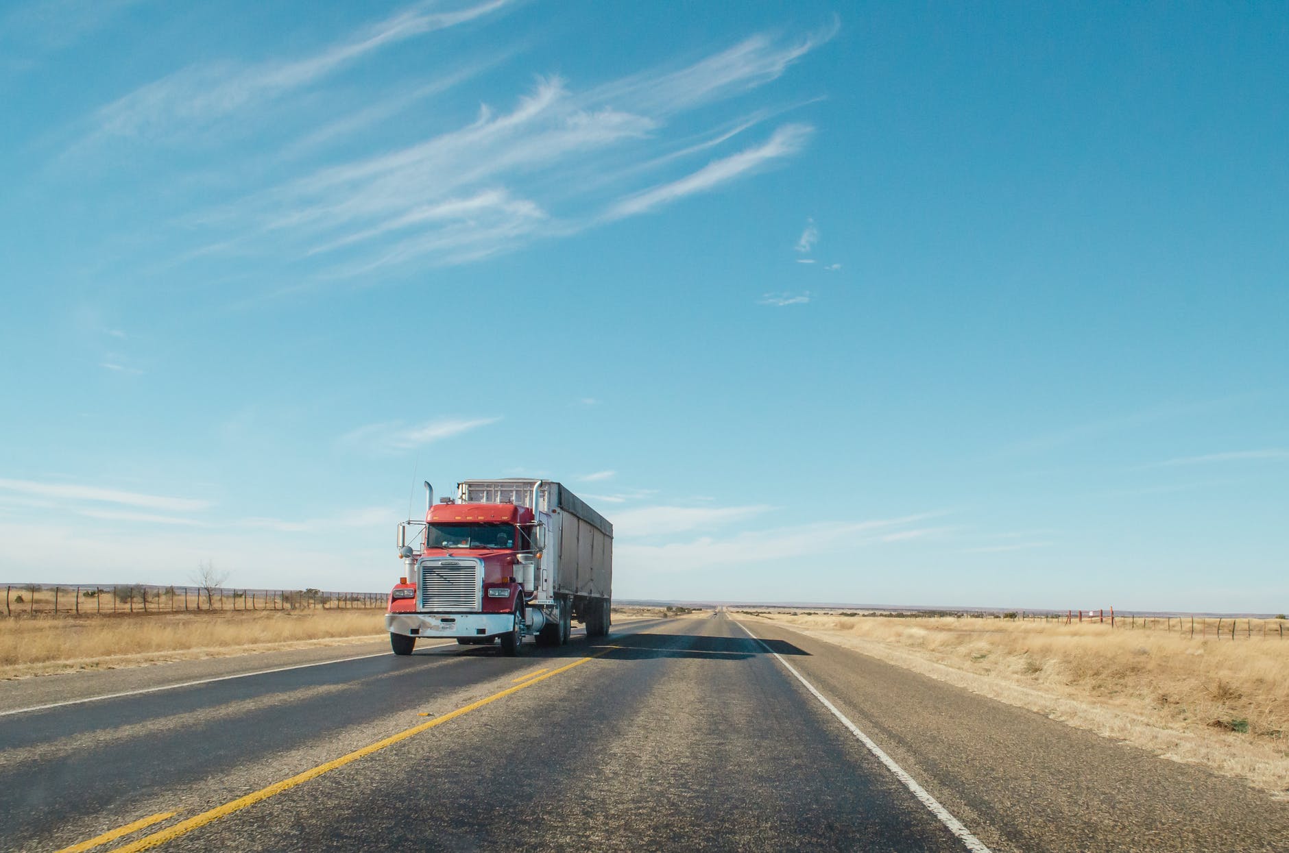 red and white truck on road under blue sky